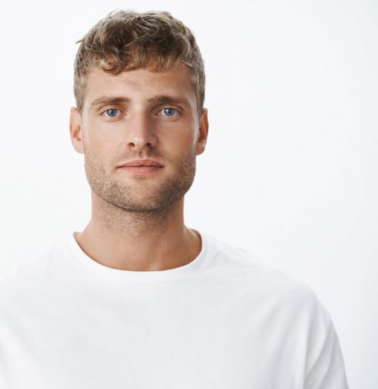 waist-up-shot-handsome-calm-blond-blue-eyed-guy-with-bristle-white-t-shirt-looking-front-with-relaxed-carefree-facial-expression-posing-gray-wall-looking-sincere-chill 1-1